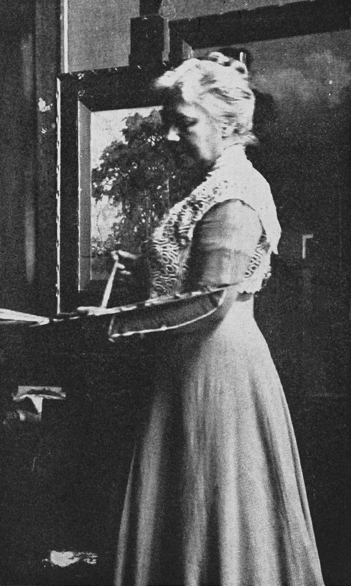 Mary Hiester Reid in her studio with painter's palette, date unknown